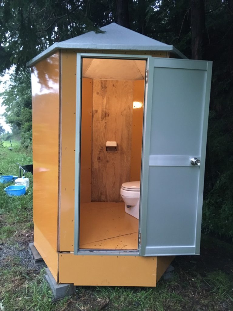 現地で組み立てた六角形のトイレ小屋です。おがくず投下式の場合、土台の高さが３０センチ程度必要になります。